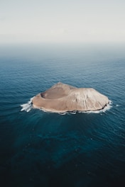 brown rock formation on blue sea during daytime