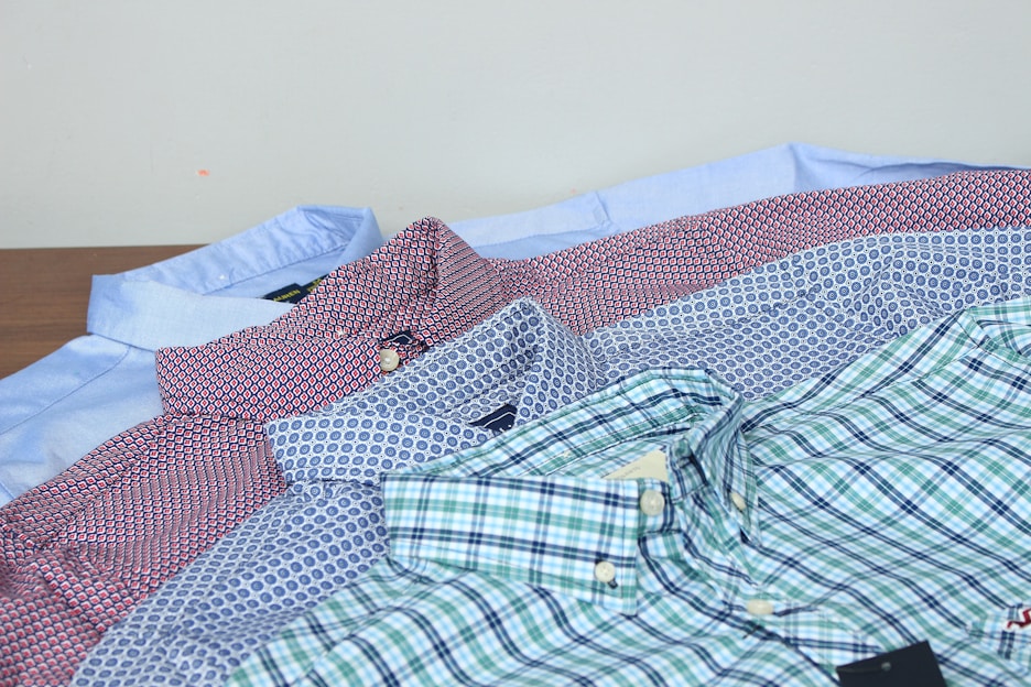 A neatly arranged display of men’s formal shirts in various colors and patterns.