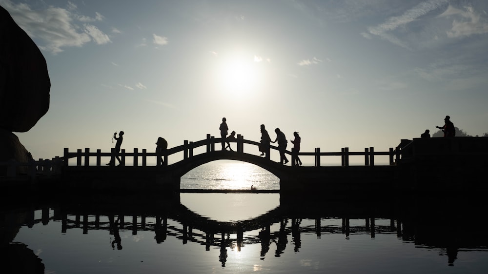silhouette of bridge over water during daytime