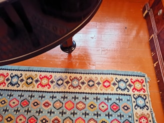 A clean, vibrant rug being treated with eco-friendly cleaning products on a wooden floor.