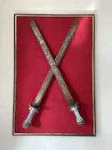 An artistic interpretation of the Five of Swords featuring stormy skies and scattered swords.
