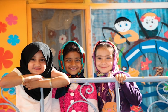 2 women smiling and standing near wall