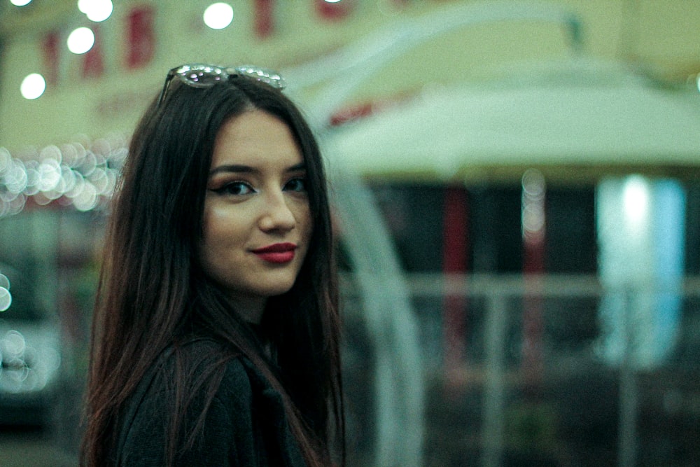 woman in black shirt standing near glass window