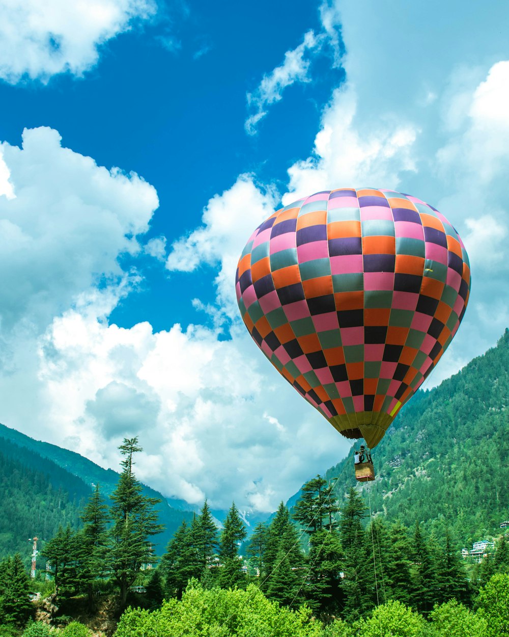 mongolfiera gialla, rossa e blu sotto il cielo blu e le nuvole bianche durante il giorno