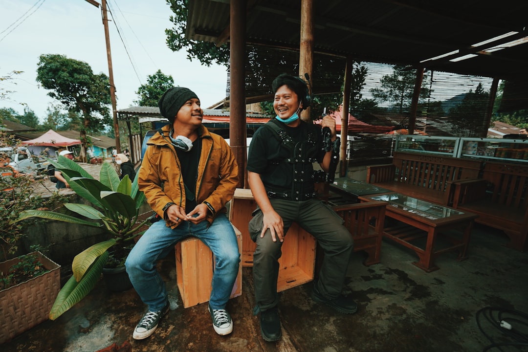 man and woman sitting on brown wooden bench