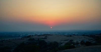 Sunset over a spacious land plot with distant city views.