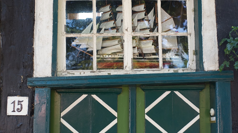 white and green wooden framed glass window