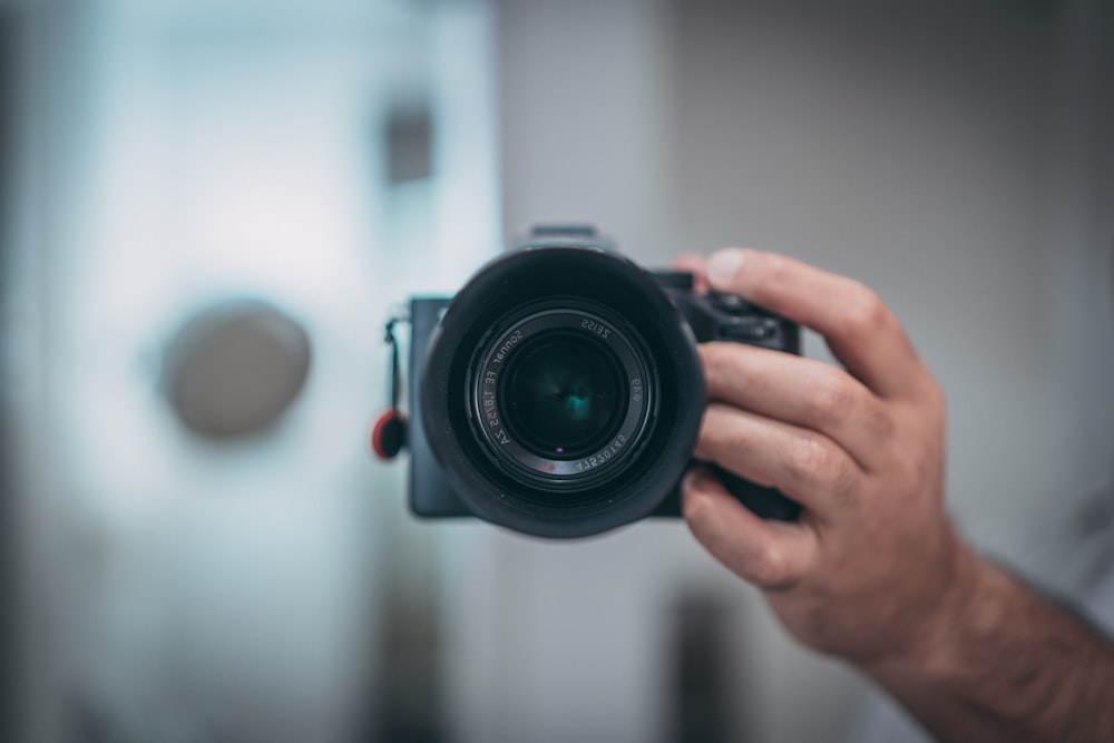 person holding black dslr camera