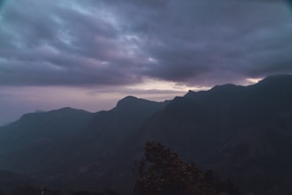 A still from a moody travel film capturing a sunset over rugged mountains.