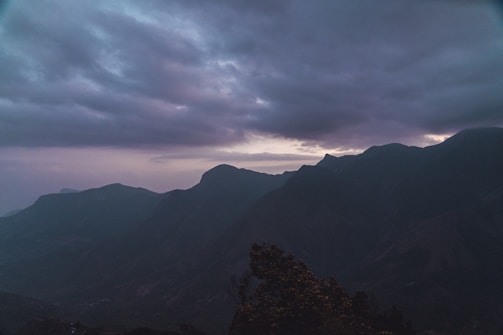 A still from a moody travel film capturing a sunset over rugged mountains.