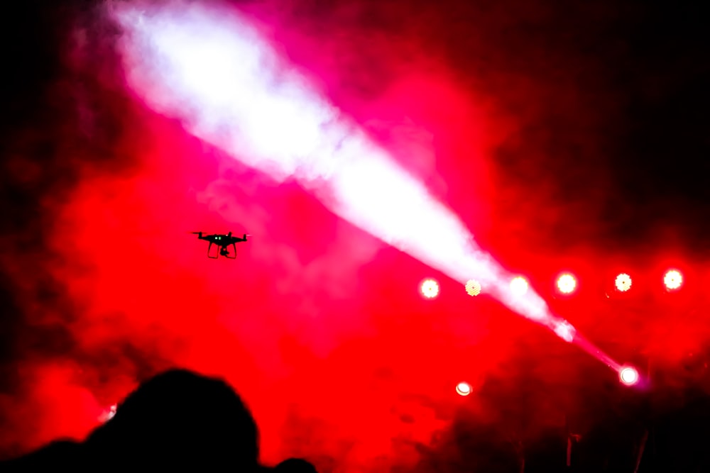 silhouette of airplane flying over the sky during night time