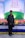 A man stands in front of a colorful display with a banner reading 'Annual Conference 2021' from 'bestelectronics'. The backdrop features a green field design with abstract figures. The area is decorated with a vibrant array of flowers and a draped tablecloth.
