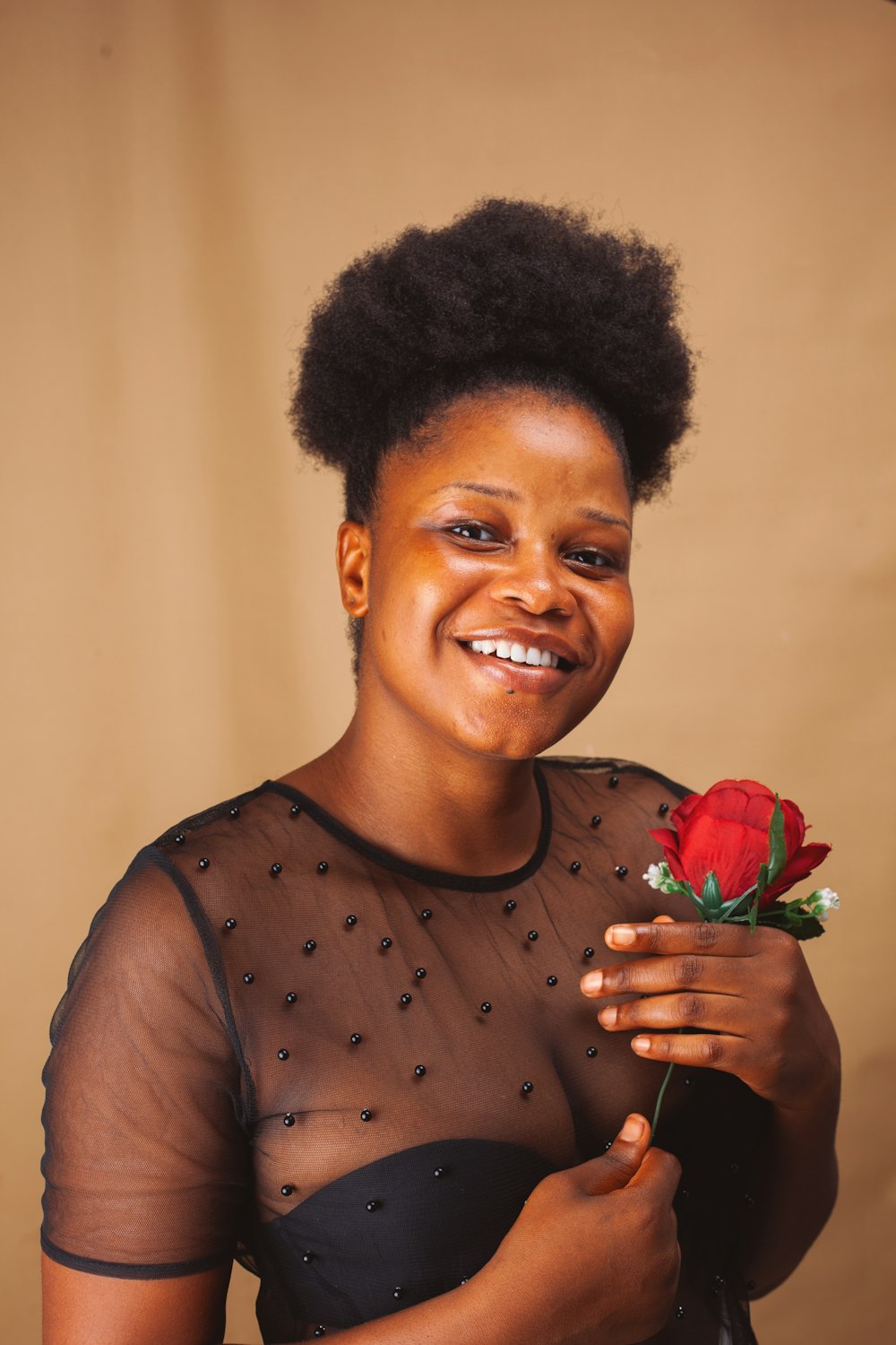 woman in gray tank top holding red rose