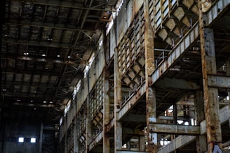 A group of urban explorers walking carefully through an abandoned industrial building with natural light streaming in.