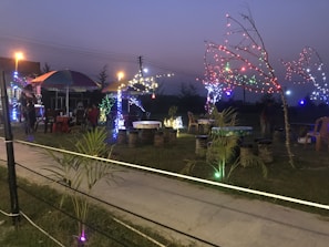 A festive outdoor catering setup with colorful decorations and happy guests enjoying Bayou Bistro food