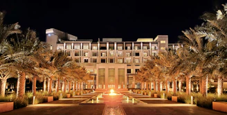 Elegant entrance of MD Palace banquet hall glowing warmly at dusk.