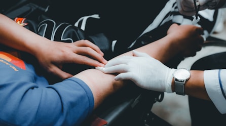 person in blue long sleeve shirt holding persons hand