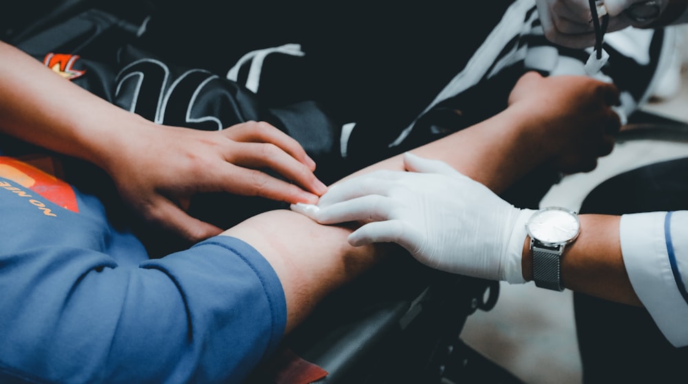 person in blue long sleeve shirt holding persons hand