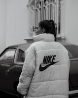 woman in white and black adidas hoodie standing near black car