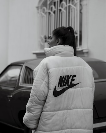 woman in white and black adidas hoodie standing near black car