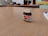 Close-up of a jar of creamy Dattera hazelnut spread with whole hazelnuts around it and a rustic wooden background