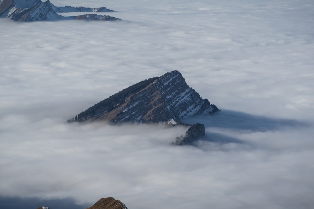 brown and black rock formation covered by white clouds