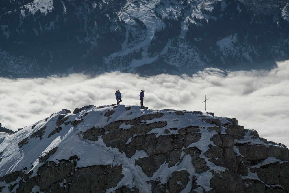Persona de pie en la montaña de roca gris bajo el cielo azul durante el día