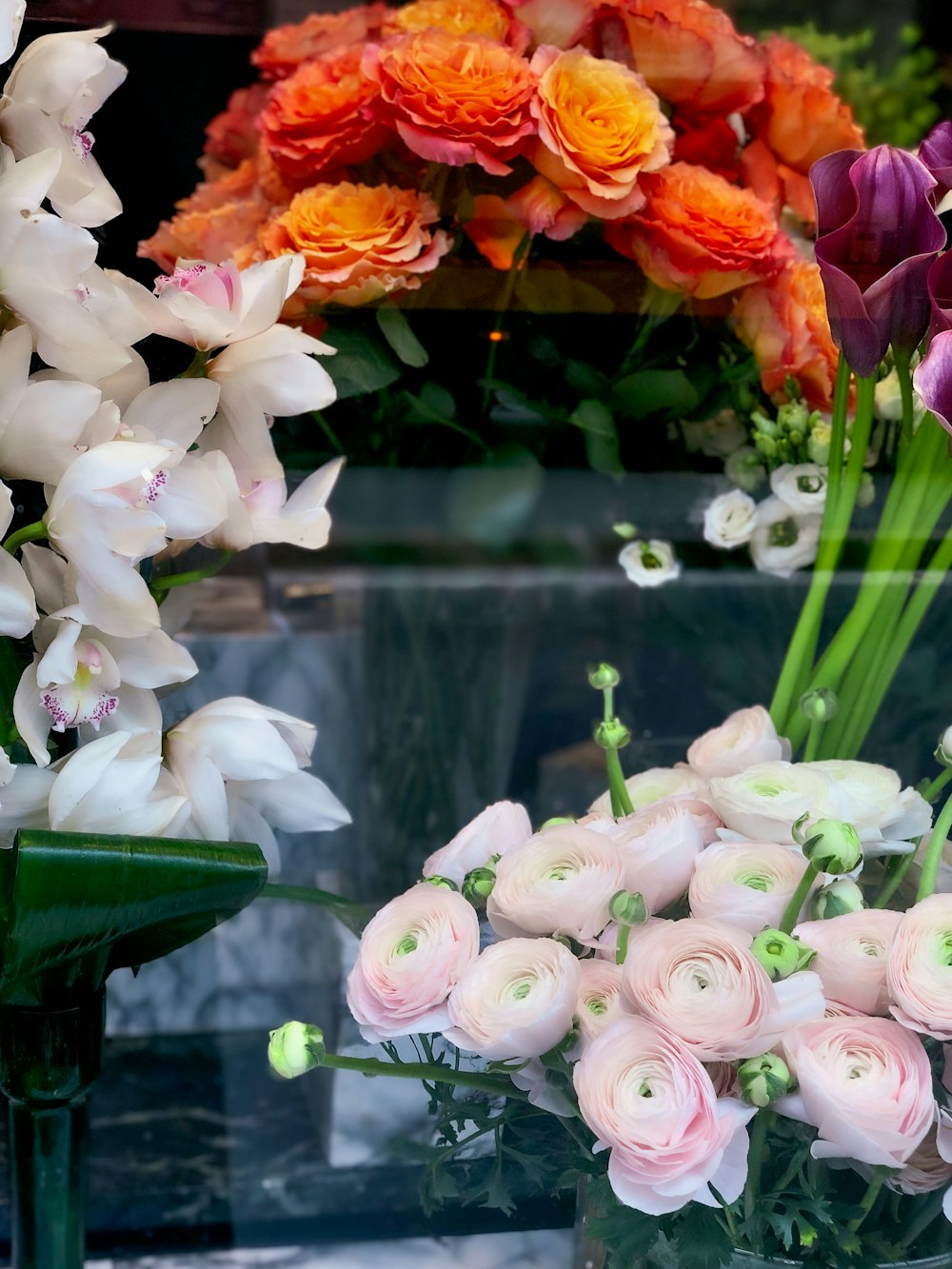 white and pink roses in green glass vase