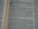 A close-up view of an open book, displaying text in a serif font. The focus is on several paragraphs with headings and lines of content, featuring dialogue and narrative elements.