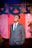man in gray suit standing near red curtain