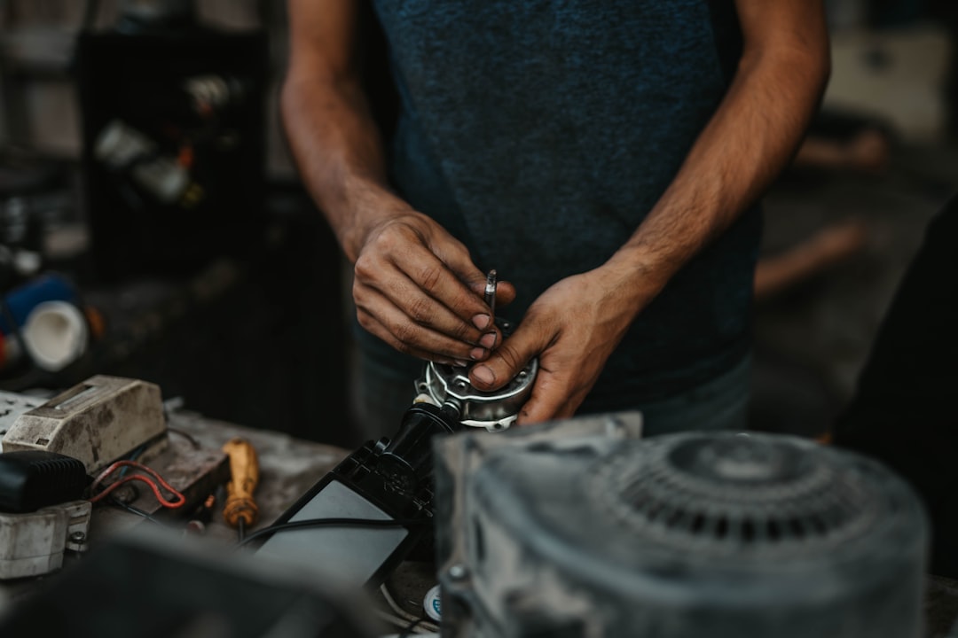 man in black t-shirt holding black metal tool