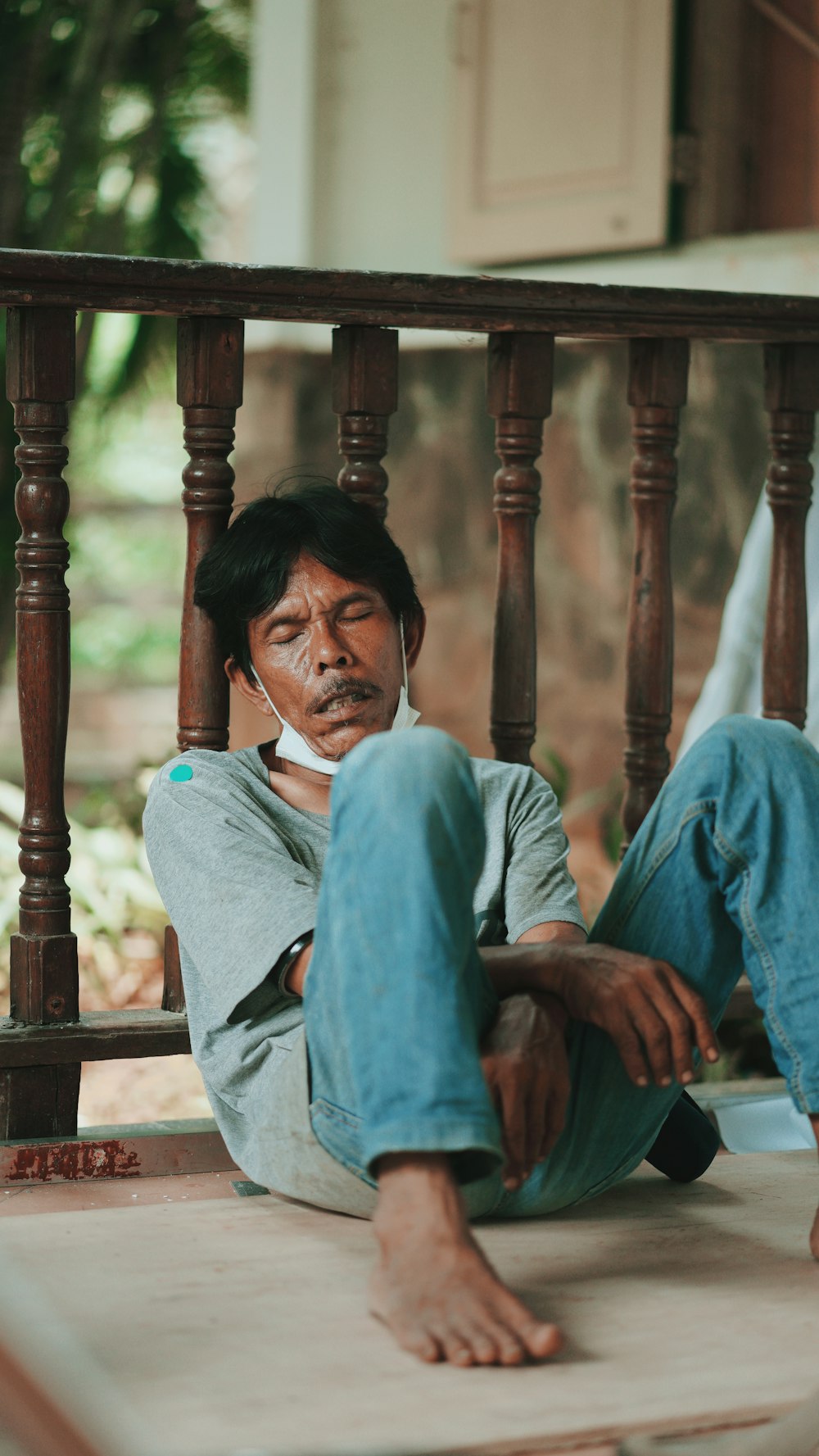 man in blue long sleeve shirt sitting on brown wooden chair