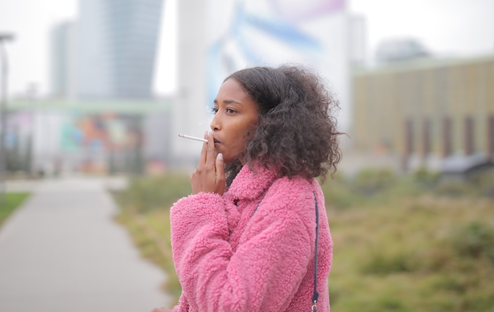 woman in pink sweater holding her chin