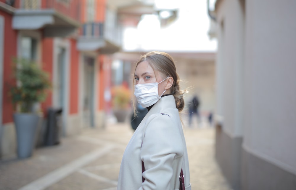 woman in white coat wearing white face mask