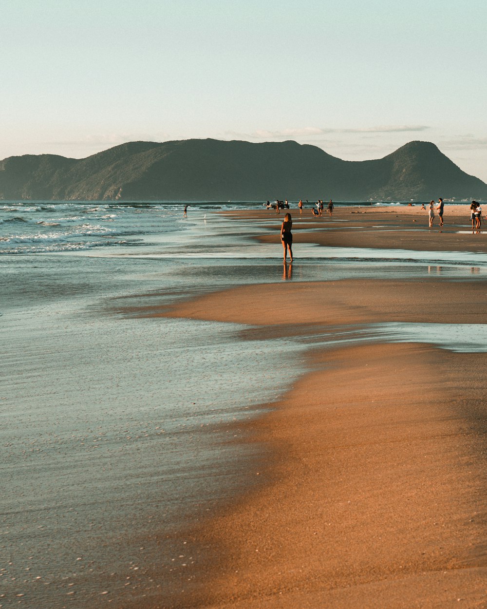 person standing on beach shore during daytime