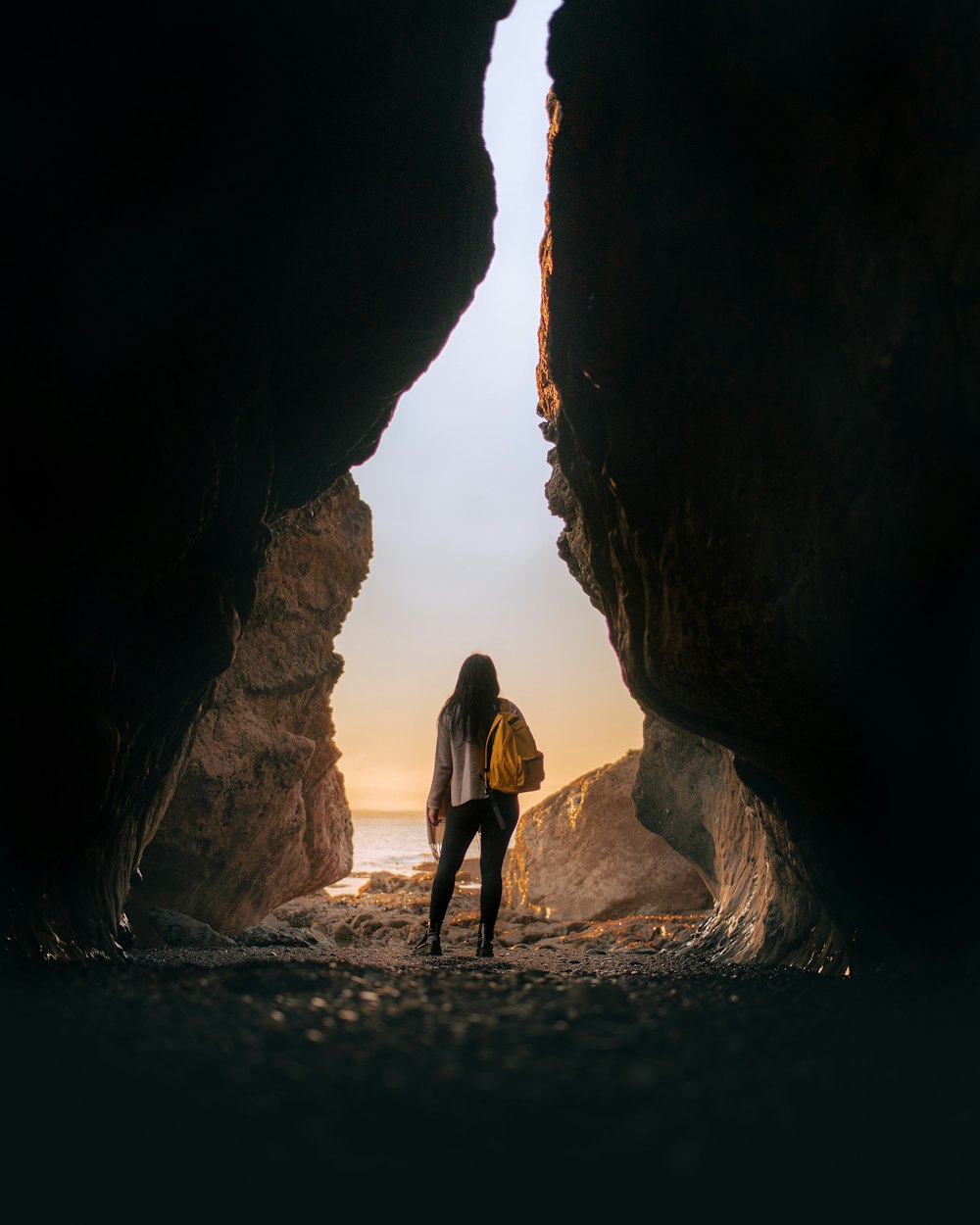 woman in black dress standing on brown rock formation during daytime