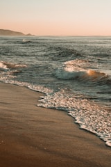 ocean waves crashing on shore during daytime
