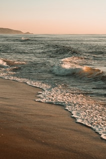 ocean waves crashing on shore during daytime