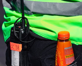 orange and black bottle on black and green bag