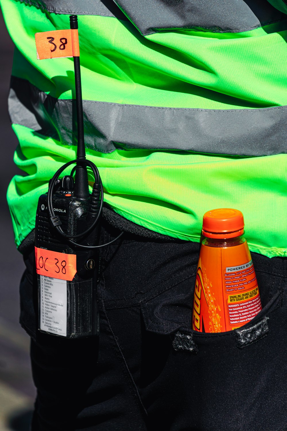 orange and black bottle on black and green bag