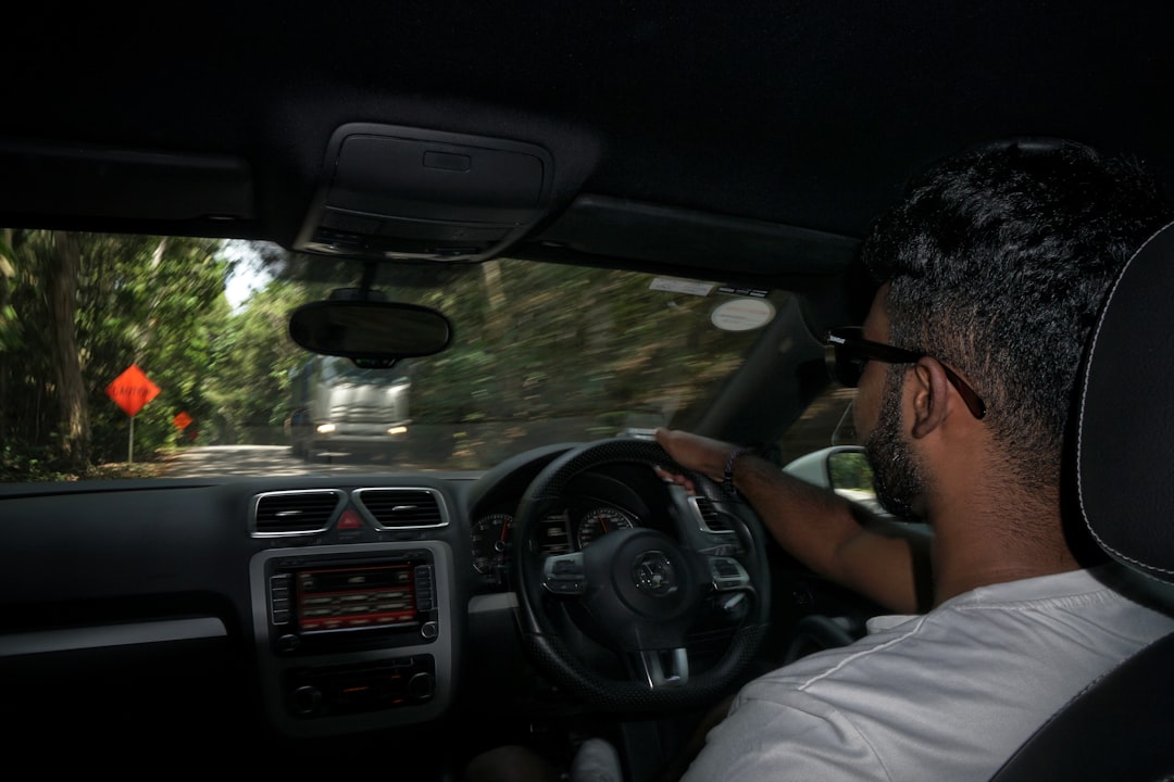 man in white shirt driving car