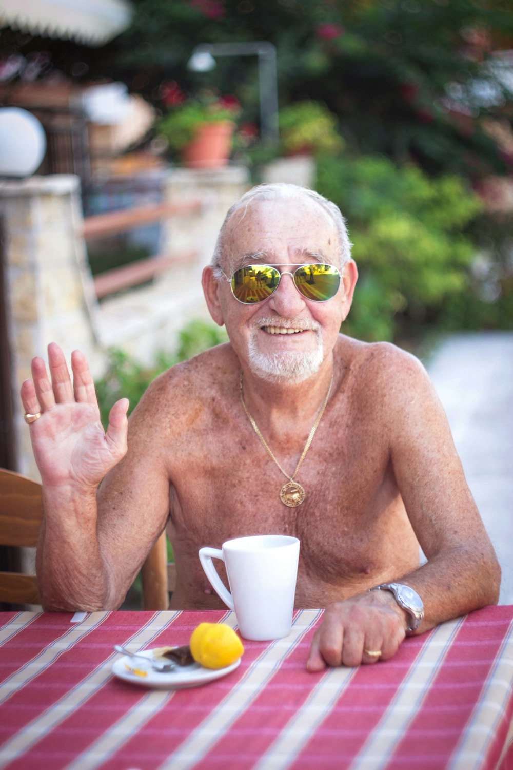 topless man wearing sunglasses sitting on chair