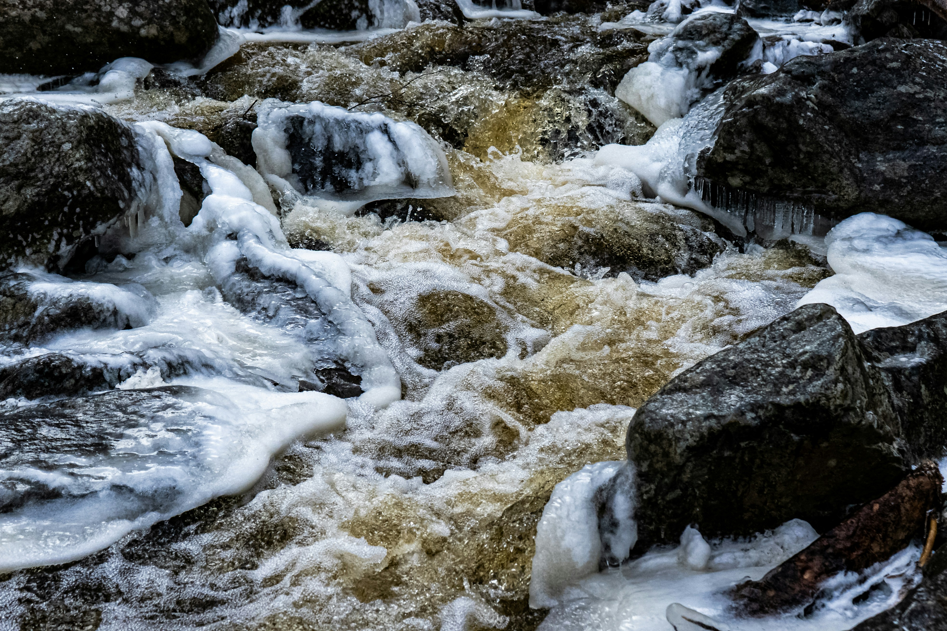 white and gray rock formation on body of water during daytime