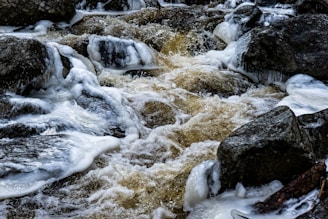 white and gray rock formation on body of water during daytime