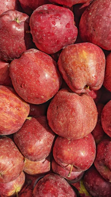 Crisp red apples stacked in a pyramid with dewdrops glistening.