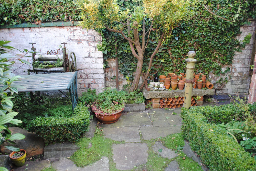 Sfeerbeeld van een kleine ommuurde patio met groen