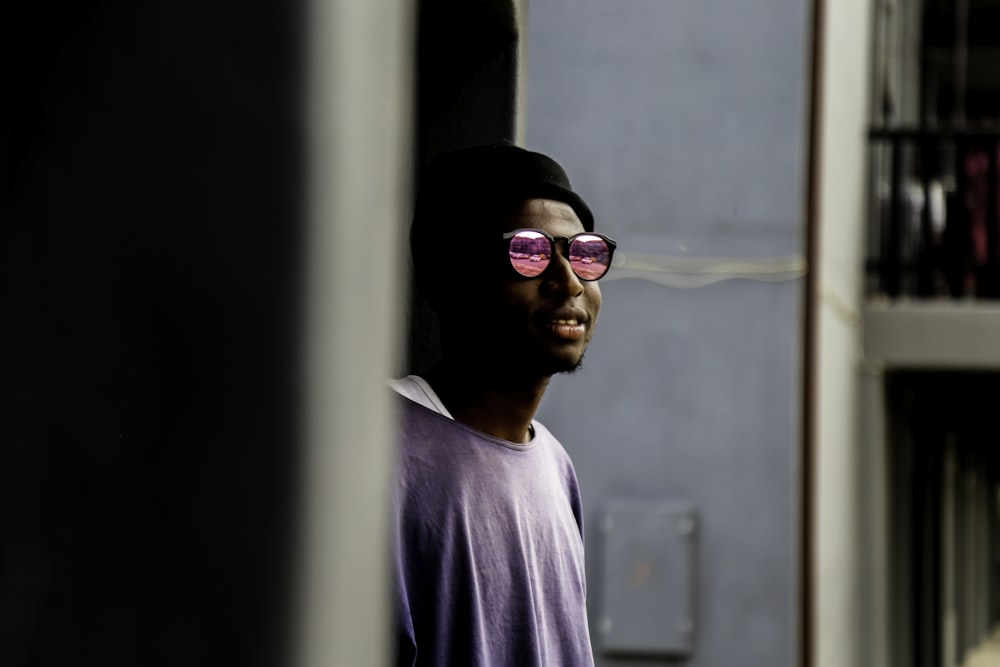 man in purple crew neck shirt wearing black sunglasses