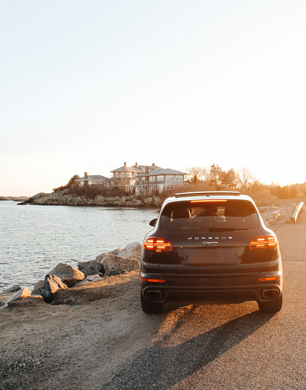 brown car on gray sand near body of water during daytime