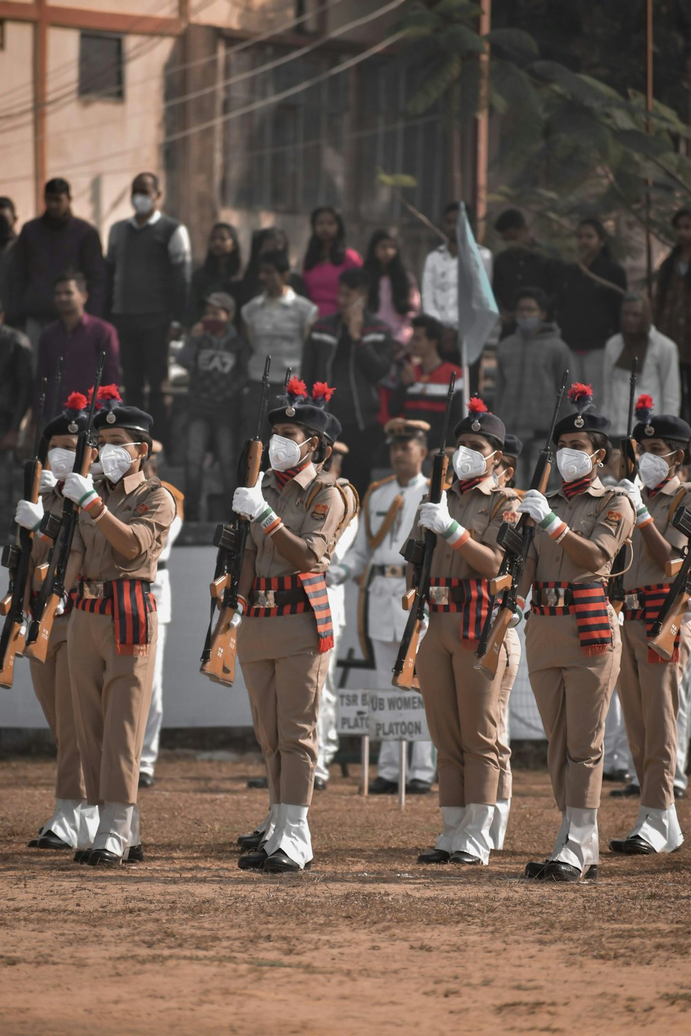 group of men in brown and black uniform standing on brown field during daytime