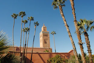beige concrete building near palm trees under blue sky during daytime